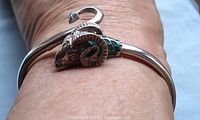 Bangle worn on wrist showing ram head and curled tail with green enamel neck