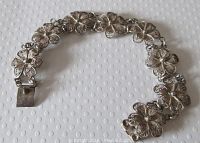 Full view of vintage sterling silver floral filigree link bracelet showing entire length and push-in clasp.