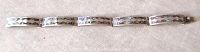 Full length view of vintage sterling silver bracelet showing hammered texture and five linked sections.