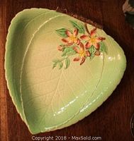 Top view of the ceramic dish showing leaf shape, green glaze, flower decoration, and embossed leaf veins.
