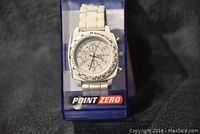 Front view of new Point Zero chronograph watch inside original blue plastic case, white band and face, clear branding visible.