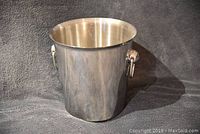 Front view of the stainless steel ice bucket showing reflective surface and one handle on the side.