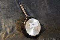 Side and handle view of a black frying pan with non-stick coating and metal handle, showing the shape and design of the pan.