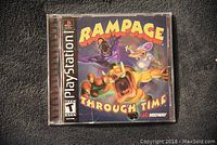 Front cover of Rampage Through Time PlayStation game case showing colorful cartoon monster artwork and game title