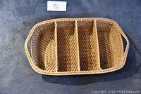 Top-down view of rectangular wicker basket showing four compartments divided by woven separators, natural light brown color.
