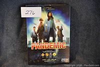 Photo of the front box cover showing Pandemic board game by Matt Leacock with artwork and awards.