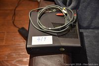 Xbox 360 console with composite AV cable on top showing front and side angle