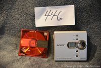 Sony Walkman MiniDisc player with red MiniDisc and lot number card.
