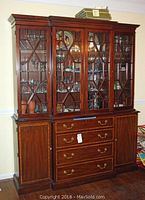 Overall front view of two-piece china cabinet showing top glass display section and lower storage base.