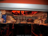 View showing storage shelves with various kitchen items including plates, plastic containers, and pans