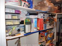 Shelves stocked with various boxes, packages and plastic trays of envelopes, paper and other office supplies.