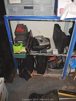 Shelving with various tools including a black toolbox, and a coiled yellow measuring tape