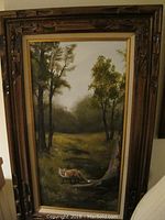 Vertical painting of a fox in a forest scene with a carved dark wood frame