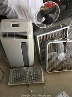 All five fans including the DeLonghi PAC A110 portable air conditioner and four various fans visible and grouped on the floor
