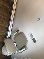 Full view of the Pinnacle chair lift installed on straight staircase showing seat, armrests and rail