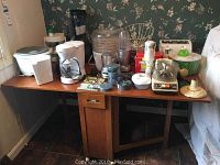 Full view of the kitchen table with various kitchen appliances on top to show size and top condition.