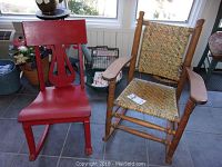 Pair of rocking chairs seen side by side, red wooden chair on left and natural wood cane chair on right.