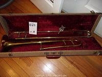 Full view of trombone inside the hard case showing entire instrument and the case lining.