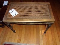 Top-down view showing cane seat with minor wear and bench frame.