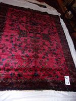 Full view of rectangular oriental area rug laid on white sheet