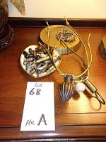 View of assorted lamp parts including harp frames, various finials, and lamp base