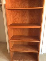 Close-up photo showing the shelves and wood grain inside one bookcase.