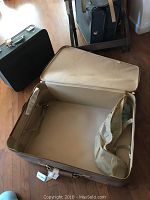 Image showing an open beige hard case suitcase with beige fabric lining and interior straps.
