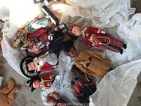 Various collectible dolls and puppets arranged with Venezuelan hammock fabric, including traditional costumes and plush toys visible.