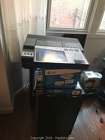 Photo of stacked electronics including RCA VHS player, AT&T wireless router box, and two large black speakers.