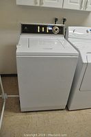Front view of white Maytag top-load washing machine alongside another unit