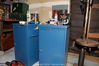 Photo showing two blue metal tool cabinets side by side with various items on top including caulking and adhesive tubes.