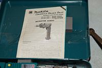 Instruction manual for Makita cordless drill inside metal case lid.