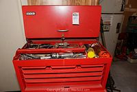 Red Stack-On tool chest open showing various metal hand tools including socket sets, wrenches, and tools in the top compartment