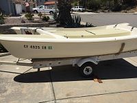 Starboard side view of catamaran hull on trailer showing hull shape, registration and trailer details