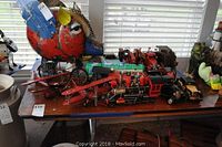 Overview of lot showing bird sculpture on left and various vehicles lined up