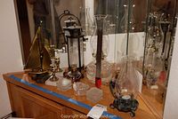 Wide angle showing all glassware and metal items on a wooden surface with mirrored background