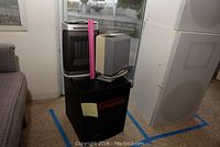 Three portable heaters stacked; older box heater, compact beige/gray heater, modern black mesh heater.