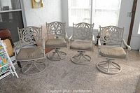 Overview of four metal swivel rocker patio chairs with cushions