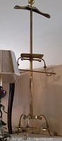 Full view of vintage brass valet stand showing hanger, tray, rod and tripod base