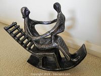 Side angled view showing the mother holding the child seated on the rocking chair