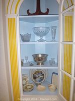 Glass cabinet with crystal and porcelain items: footed vase, trophy bowl, wall plate, crystal glasses, metal bowl, porcelain plates and bowls