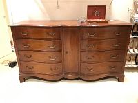 Full frontal view of dresser showing curved front, drawer arrangement, center cabinet and top surface