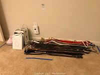 Overview photo showing multiple ladies belts laid out on carpet floor with designer packaging bags nearby.