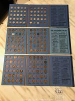 Six blue cardboard boards showing slots and inserted Lincoln cents alongside a printed price guide board
