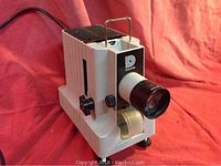 Front view of vintage Dukane film projector showing lens, brand logo and body design.