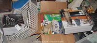 Photo of cleaning supplies, metal organizing racks, and boxed kitchen cups arranged in boxes and bags.
