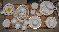Overview of complete set showing stacks of plates, cups, bowls and serving pieces in cardboard box