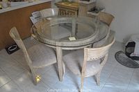 Overview of round glass-top dining table with four chairs