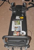 Top view of Pilates Power Gym Pro platform showing foot straps, resistance cords, exercise booklets, and CDs.
