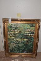 Full view of framed Water Lily Pond painting showing impressionist style water lilies and pond with ornate gold frame.